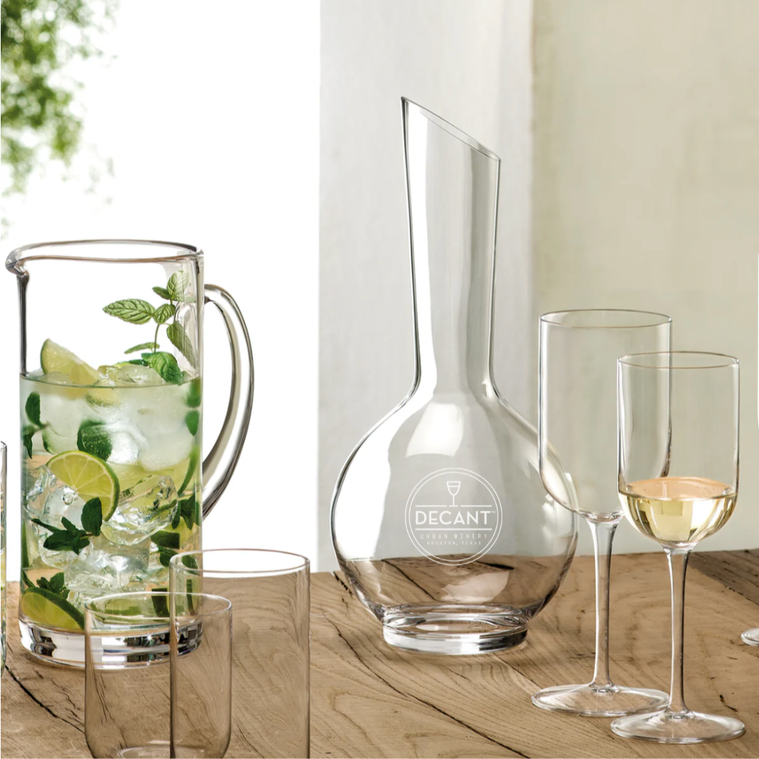 
                  
                    Set of glassware including a pitcher, carafe, and wine glasses on a wooden surface.
                  
                